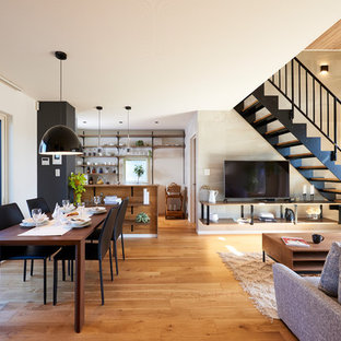 На фото: с невысоким бюджетом гостиные-столовые среднего размера в современном стиле с белыми стенами, паркетным полом среднего тона и коричневым полом без камина