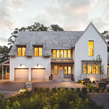 Modern Mediterranean Exterior with White Brick, Gabled Rooflines & Warm Wood Gar