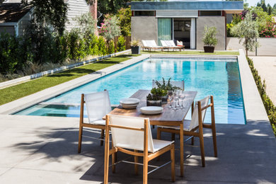 Imagen de casa de la piscina y piscina infinita tropical grande rectangular en patio con granito descompuesto