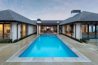 This is an example of a large tropical courtyard rectangular lap pool in Auckland with concrete slab.