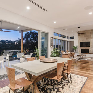 This is an example of a contemporary open plan dining in Sydney with white walls, medium hardwood floors and beige floor.