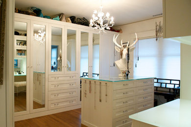 Photo of a large eclectic dressing room in Vancouver with white cabinets, medium hardwood floors, brown floor and vaulted.