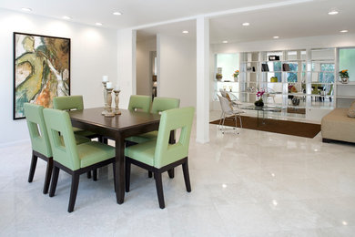 This is an example of a mid-sized contemporary open plan dining in Los Angeles with white walls and limestone floors.
