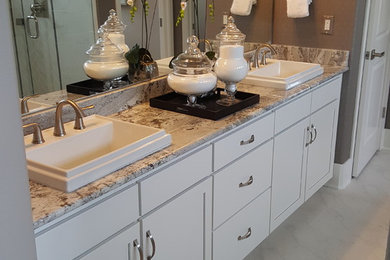 Inspiration for a mid-sized timeless master white tile and porcelain tile marble floor bathroom remodel in Denver with recessed-panel cabinets, white cabinets, gray walls, a drop-in sink and marble countertops