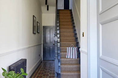 This is an example of a mid-sized modern hallway in London with beige walls, ceramic floors and brown floor.