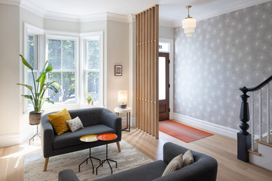 Living room - transitional light wood floor and wallpaper living room idea in New York