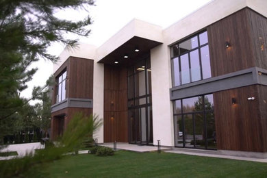 Diseño de fachada de casa contemporánea grande de dos plantas con revestimientos combinados