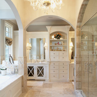 Exemple d'une douche en alcôve chic avec des portes de placard blanches, un carrelage beige et du carrelage en pierre calcaire.