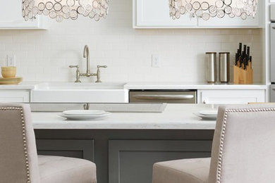 Example of a small transitional eat-in kitchen design in Other with a farmhouse sink, recessed-panel cabinets, white cabinets, soapstone countertops, white backsplash, ceramic backsplash, stainless steel appliances and an island