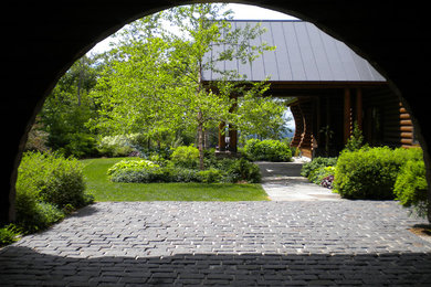 Patio - mid-sized rustic backyard concrete paver patio idea in Burlington with a roof extension