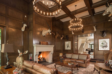 Inspiration for a country open concept family room in Austin with brown walls, dark hardwood floors, a standard fireplace, a metal fireplace surround and brown floor.