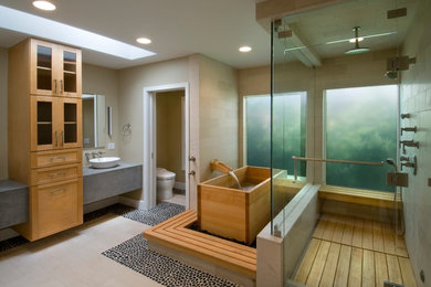 Inspiration for a contemporary bathroom in Los Angeles with a japanese tub, a vessel sink, pebble tile floors and an enclosed toilet.