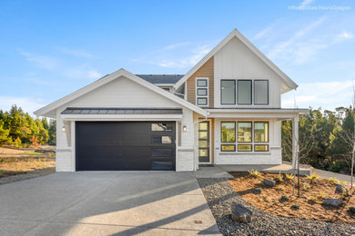 Example of a mid-sized country white two-story concrete fiberboard and clapboard exterior home design in Portland with a mixed material roof and a black roof