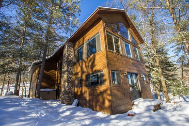 Inspiration for a rustic brown concrete house exterior remodel in Other
