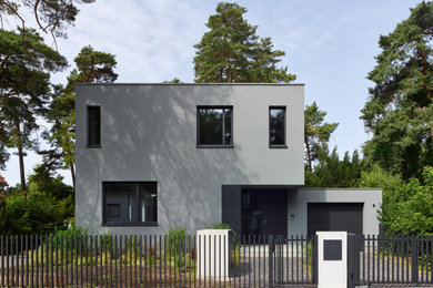 Mittelgroßes, Zweistöckiges Modernes Haus mit Putzfassade, grauer Fassadenfarbe und Flachdach in Berlin