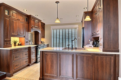 Inspiration for a mid-sized timeless l-shaped travertine floor eat-in kitchen remodel in Montreal with a double-bowl sink, raised-panel cabinets, brown cabinets, laminate countertops, beige backsplash, stone tile backsplash, black appliances and a peninsula