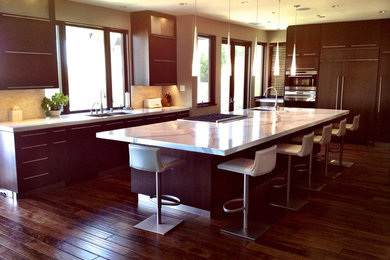 Kitchen - large contemporary l-shaped medium tone wood floor and brown floor kitchen idea in San Diego with an undermount sink, flat-panel cabinets, medium tone wood cabinets, quartzite countertops, beige backsplash, stone tile backsplash, paneled appliances and an island