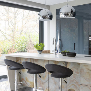 Large contemporary kitchen pantry appliance - Kitchen pantry - large contemporary galley porcelain floor and gray floor kitchen pantry idea in Hertfordshire with an undermount sink, flat-panel cabinets, distressed cabinets, quartzite countertops, black appliances, an island and white countertops