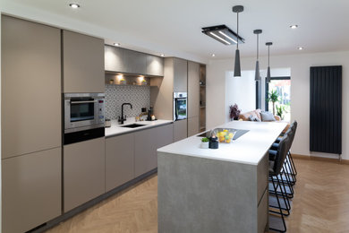 This is an example of a modern kitchen in Other with flat-panel cabinets, beige cabinets, concrete worktops, multi-coloured splashback, stainless steel appliances and an island.