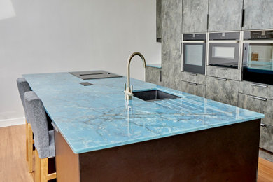 Imagen de cocina comedor de tamaño medio con puertas de armario grises, encimera de cuarcita, una isla y encimeras azules