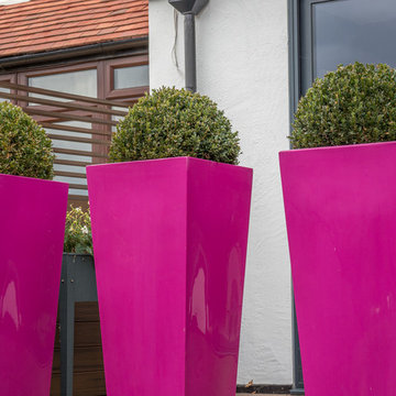 Tapered tall planters divide and offer a safety barrier on the raised decking.