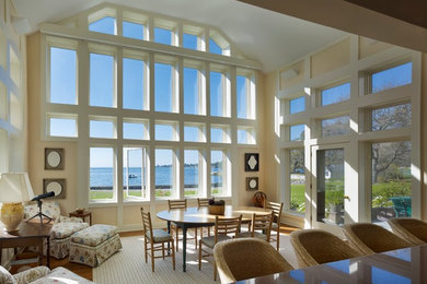 Example of a large beach style medium tone wood floor great room design in New York with beige walls and no fireplace