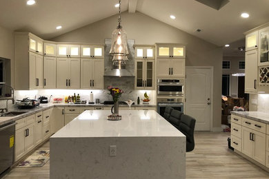 Large modern u-shaped eat-in kitchen in San Francisco with an undermount sink, shaker cabinets, white cabinets, wood benchtops, multi-coloured splashback, subway tile splashback, stainless steel appliances, porcelain floors, with island, grey floor and white benchtop.