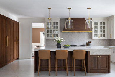 Eat-in kitchen - large transitional l-shaped porcelain tile and beige floor eat-in kitchen idea in DC Metro with an integrated sink, shaker cabinets, brown cabinets, marble countertops, beige backsplash, quartz backsplash, stainless steel appliances, an island and beige countertops