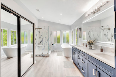 Large ceramic tile vinyl floor, beige floor and double-sink bathroom photo with shaker cabinets, blue cabinets, gray walls, an undermount sink, quartz countertops, a hinged shower door, white countertops and a built-in vanity
