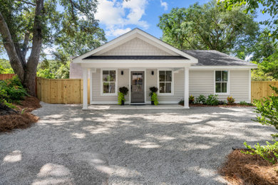 Example of a mid-sized minimalist beige one-story vinyl and clapboard house exterior design in Charleston with a shingle roof and a gray roof