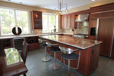 Example of a large transitional l-shaped slate floor kitchen design in Other with an undermount sink, recessed-panel cabinets, medium tone wood cabinets, granite countertops, multicolored backsplash, matchstick tile backsplash, stainless steel appliances and an island