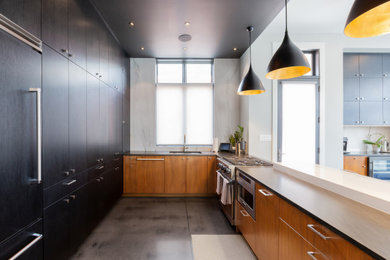 Mid-sized minimalist u-shaped concrete floor and black floor eat-in kitchen photo in Indianapolis with an undermount sink, flat-panel cabinets, black cabinets, marble countertops, multicolored backsplash, marble backsplash, stainless steel appliances, an island and black countertops