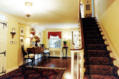 Example of a large classic dark wood floor entryway design in Cleveland with yellow walls and a white front door