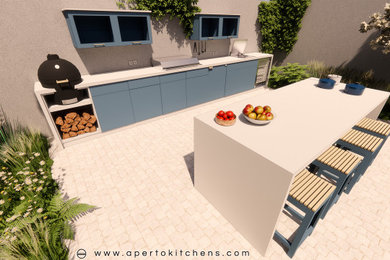 This is an example of a large contemporary side patio in London with an outdoor kitchen, natural stone paving and a pergola.