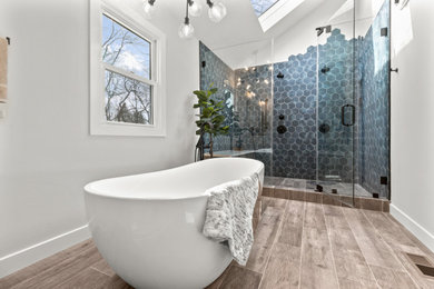 Inspiration for a large classic bathroom in Philadelphia with white cabinets, a freestanding bath, a double shower, a one-piece toilet, blue tiles, porcelain tiles, grey walls, porcelain flooring, a submerged sink, quartz worktops, brown floors, a hinged door, white worktops, double sinks and a built in vanity unit.