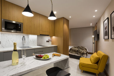 Foto de sala de estar abierta moderna de tamaño medio con paredes grises, suelo de baldosas de porcelana, televisor colgado en la pared, suelo gris y panelado