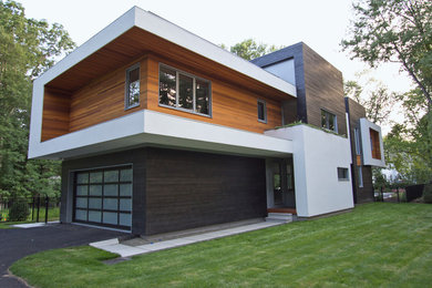 This is an example of a large modern two-storey multi-coloured house exterior in Bridgeport with mixed siding and a flat roof.