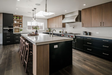 Inspiration for a contemporary u-shaped medium tone wood floor and brown floor open concept kitchen remodel in San Francisco with a farmhouse sink, flat-panel cabinets, black cabinets, quartz countertops, gray backsplash, quartz backsplash, stainless steel appliances, an island and gray countertops