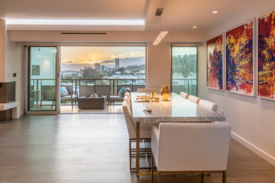Example of a large trendy light wood floor and beige floor great room design in Los Angeles with white walls