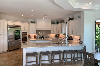 Large contemporary u-shaped eat-in kitchen in Miami with an undermount sink, shaker cabinets, white cabinets, quartzite benchtops, beige splashback, stone slab splashback, stainless steel appliances, marble floors, with island, beige floor and beige benchtop.