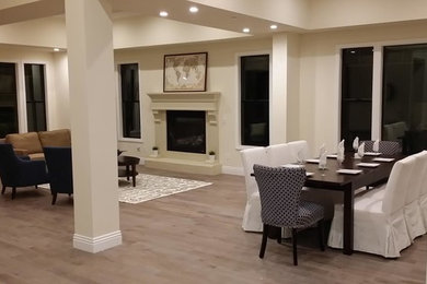 Great room - modern light wood floor great room idea in Los Angeles with beige walls, a standard fireplace and a stone fireplace