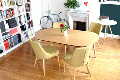 Aménagement d'une salle à manger contemporaine fermée et de taille moyenne avec un mur blanc, parquet clair, une cheminée standard et un sol marron.