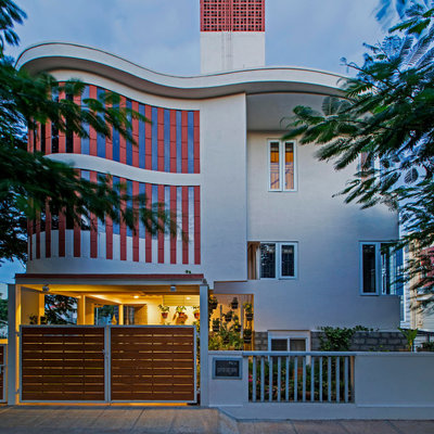 Example of a trendy gray three-story house exterior design in Bengaluru