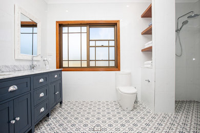 Mid-sized contemporary master bathroom in Sydney with blue cabinets, a double shower, a one-piece toilet, white tile, ceramic tile, white walls, ceramic floors, an integrated sink, granite benchtops, blue floor and an open shower.