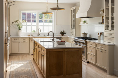 Example of a huge u-shaped light wood floor eat-in kitchen design in DC Metro with an undermount sink, shaker cabinets, light wood cabinets, quartz countertops, white backsplash, quartz backsplash, paneled appliances, an island and white countertops