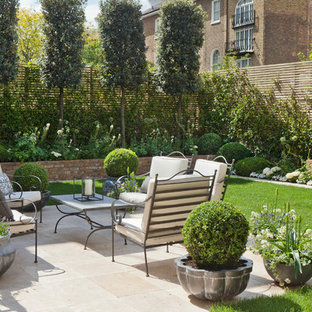 Unbedeckter Klassischer Patio hinter dem Haus mit Kübelpflanzen und Natursteinplatten in London
