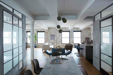 Example of a mid-sized minimalist formal and loft-style medium tone wood floor and brown floor living room design in New York with gray walls, no fireplace and a wall-mounted tv
