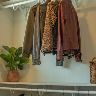 Exemple d'un très grand dressing chic neutre avec un sol en bois clair, un sol marron et un plafond en lambris de bois.
