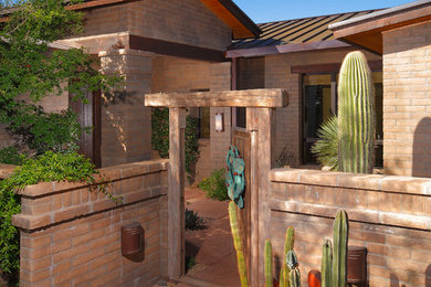 Entryway - large rustic terra-cotta tile entryway idea in Phoenix with beige walls and a medium wood front door