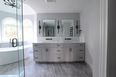 Freestanding bathtub - master double-sink freestanding bathtub idea in Portland with shaker cabinets, gray cabinets, a bidet, quartz countertops, a hinged shower door and a freestanding vanity